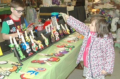 Corbin Tingesdal, a fourth grader at Bear Cave Intermediate School, left, welcomed plenty of customers to his booth at the Stewartville Area Historical Society's 23rd annual Cabin Fever Flea Market on Feb. 16. Harper Phillips, 4, of Lanesboro, Corbin's cousin, hands Corbin cash for the items she purchased.