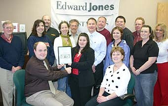 A WARM WELCOME -- The Stewartville Area Chamber of Commerce welcomed Edward Jones' Jason Geving, seated at left, and Ruth Oelkers, seated at right, to the local business community with an official ambassador visit last week. Stacy Savoy, first vice president of the Chamber of Commerce, standing front and center, presents Geving with a "first dollar earned" plaque. Other Chamber members include,  second row, from left, Larry Gray, Margaret Nelson,  Jodi Beck, Chamber administrator; Mark Rusciano, Chris Dahle and Stephanie Fossum.  Back row, from left, Lloyd Anderson, Chris Stafford, Bill Schimmel Jr., Monte Beck, Chris Gray and Beth Schmidt. 