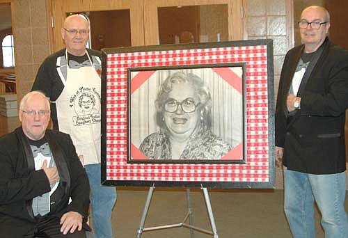 The St. Bernard's Catholic Church&#8200;Men's Club will present its biennial Mama Tranchita Spaghetti Dinner at Riverview Greens Country Club on Tuesday, April 9, with seating from 5 p.m. to 8:30 p.m. From left. flanking a photograph of Mama Tranchita, are Steve Sturm, a waiter; Dick Koenigs, chef; and Rob Miller, who will work in a number of capacities at the dinner.