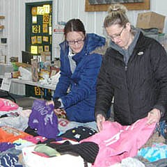 Fawn Gruhlke, left, and Misty Murray, cousins from Stewartville, search among the many articles of clothing available at the Grisim School Bus. Inc. bus barn during the 35th annual Stewartville Citywide Garage Sale on Thursday, May 9. "When the kids were little, we looked for a lot of children's clothes," Murray said. "But now the kids are older, so we don't do that anymore."
