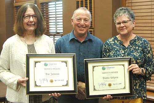 Pat Johnson, left, and Debbie Lofgren, right, recently retired from the Stewartville Public Library, accept special service awards from Mayor Jimmie-John King, center.
