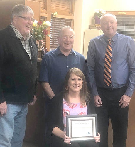 Alisha Nelson, an agent for First American Insurance Services in Stewartville, seated, accepts the EDA's Business Appreciation Award from, standing from left, Jim Kuisle, president of the EDA; Mayor Jimmie-John King, a member of the EDA; and Bill Schimmel Jr., city administrator.
