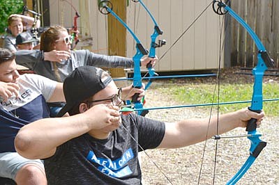 Participants at Ironwood Springs Christian Ranch's National Wheelchair Sports Camp displaying their archery skills include, from front to back, Joe Lang of Loretto, Minn.; Danny Lilya of Moose Lake, Minn.; and Brynn Duncan of Moorhead, Minn.