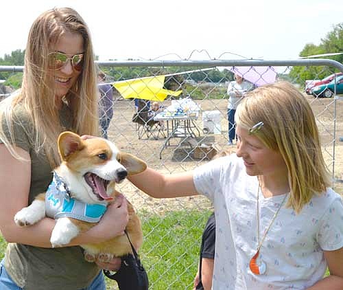 Rachel Johnson of Stewartville, left, holds Finnigan, her 3 1/2 month-old Pembroke Welsh Corgi, as Amelia Petersen, 9, also of Stewartville, says hello at the grand opening for the new Stewartville Dog Park on Saturday, June 15. Johnson said she and  her husband, Jared, plan to visit the park often. "It's definitely a large space," she said. "We enjoy it."