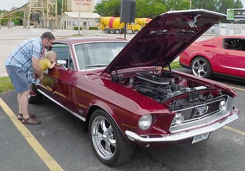 Kevin Schuessler of Bloomington, Minn. lifts his grandson, E.J. Pogue, 2 1/2, high enough to give the boy a closeup view of the inside of a 1968 Mustang Fast Back GT at the Stewie Cruisers Car Show during the Stewartville Area Chamber of Commerce's Independence Day Summerfest celebration on Thursday, July 4.