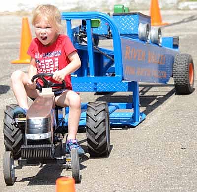 Avery Schultz, 4, churns her legs pulling weight for additional distance during the Kids Power Pedal Tractor Pull sponsored by Hammell Equipment.