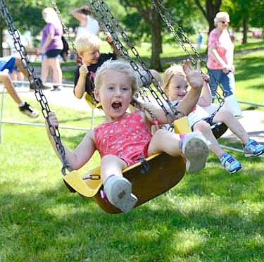 Juliette Dzubay waves and hollers "Hi!" to Mom and Dad as she enjoys the swing ride during the Stewartville Area Chamber of Commerce's annual Independence Day Summerfest celebration on a warm and muggy Thursday, July 4.