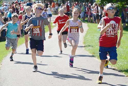 Young participants sprint with all their might at the start of the Summerfest half-mile Youth Fun Run sponsored by Fareway of Stewartville.