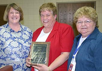 A NATIONAL HONOR -- Barb Hill, center, who has taught physical education in Stewartville schools for 27 years, has completed a number of challenging steps to achieve national certification in adapted physical education.  Ruth Vining, a member of the district's steering committee and a seventh -grade English teacher, left, told a large audience of educators at last week's staff recognition event that HIll is one of only five nationally certified physical education teachers in Minnesota.  Pat Leonard, right, is the Stewartville School District's curriculum coordinator  and a leader of the district's steering committee. 