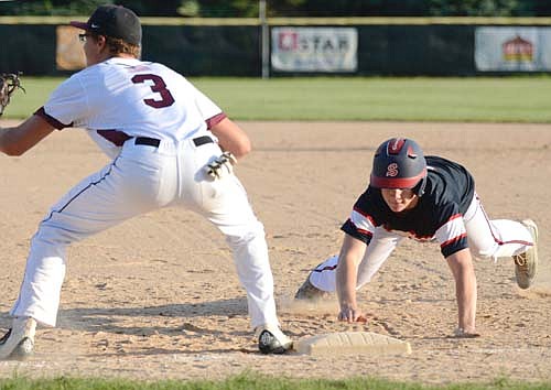 Legion base runner Justin Lewis dives back safely on this Dodge Center pickoff attempt at first base during Stewie's 7-6 win.