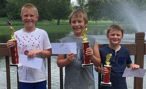 Showing off their trophies and gift certificates after winning the Summerfest Fishing Contest for ages 7-11 held July 4 at Florence Park are, from left, Caden Nagel, first place with a 9 1/4-inch bullhead; Drake , second place with a 8 3/8-inch bullhead, and Owen Nagel, third place by catching a 6 3/4-inch catfish. The event is sponsored each year by the family of Vern Billings. The deck at the Florence Park Pond was built in memory of Vern to honor his dedication to Stewartville's parks.