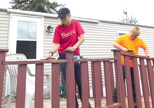 Sydney Clausen, left, and Trey Cast, both members of the Stewartville United Methodist Church, scrape the railing of the deck at the home of Lola Hall of Stewartville on Tuesday morning, July 16. The two were among 51 young people who took part in Stewartville's third annual STORM Camp.