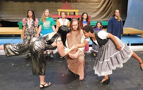 Joseph, (Dave Stepan), kneeling center, broods while Jennifer Reed, (Potiphar's wife), in the foreground at left, and Kiya Smith, foreground right, dance around him during a dress rehearsal for Stewartville Community Theatre's upcoming performances of Joseph and the Amazing Technicolor Dreamcoat, to be presented at the Stewartville Performing Arts Center beginning this Friday, Aug. 2 at 7:30 p.m. Members of the Young People's Choir, in back, include, from left, Petra Algadi, Olivia Nicklay, Matilda Dube, Flora Bolster, Sloan Bolster and Rachel Eberhard. For more about the play, see the story at left.