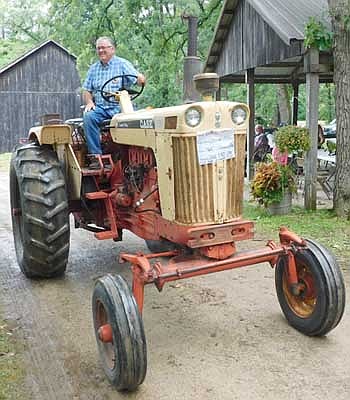 Moments before a storm brought lightning, thunder and plenty of rain, Leroy Johnson of Racine drives a 1965 Case Comfort King in the tractor parade at the Root River Antique Historical Power Association's 37th annual Antique Engine & Tractor Show  south of Racine and east of Spring Valley on Saturday, July 20.