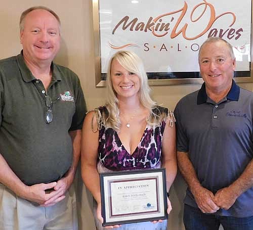 Heather Jech, owner of and hair stylist at Makin' Waves Salon, center, accepts the Economic Development Authority's Business Appreciation Award from Bill Schimmel Jr., city administrator, left, and Mayor Jimmie-John King, a member of the EDA, right.