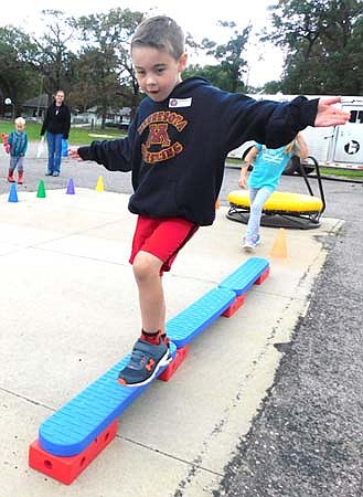 Xander Johnson, 4, a preschool student at the Central Education Center, works to keep his balance as he walks a narrow pathway at the Jumping into the School Year event at Central on Saturday morning, Sept. 14.