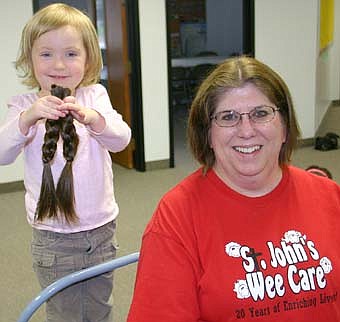 WELL-CLIPPED -- Jaida Emmons displays the two braids that will be sent to Locks of Love, an organization that makes wigs for children with cancer.  