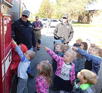 Firefighter Justin Murphy, far left, shows a fire truck to children from the Wee Care Learning Center, clockwise from center, Blake Larson, Wyatt Beyer, Avery Owen, Ellie Ferrie, Wilder Eveslage, Kinsley Bones, Oliver Gregerson-Giles, Kennedy Folkens, Kambrie Folkens and Brayden Murphy. Other firefighters who visited Wee Care on Monday, Oct. 7 include, in the background, from left, Lts. Josh Podein and Justin Lonien.