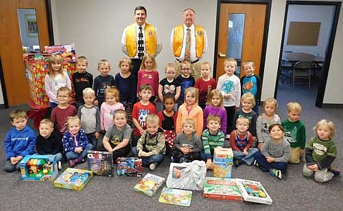 In back, from left, Troy Knutson and Bill Schimmel Jr. of the Stewartville Lions Club visited the Wee Care Learning Center at St. John's Lutheran Church on Thursday, Dec. 5 to collect gifts donated by Wee Care families to the annual Lions Club Christmas Anonymous gift and fund drive. Each year, the Lions deliver the gifts to a distribution center in Rochester, where the presents are made available to Olmsted County children who might not otherwise receive a Christmas gift.