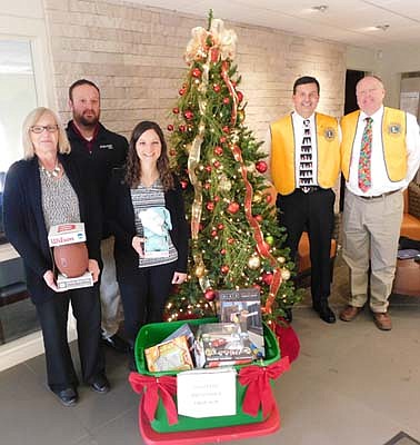 Troy Knutson and Bill Schimmel Jr. of the Stewartville Lions Club, standing left to right at the right of the Christmas tree, visited Bremer Bank on Wednesday, Dec. 11 to collect items donated by Bremer's customers and friends to the Lions Club's Christmas Anonymous gift and fund drive. Bremer Bank employees include, from far left, Lori Buchholtz, consumer banker; Mike Rainey, personal banker, and Emily Churchill, consumer banker. Logan Zenker, consumer banker, is missing from the photo. Each year, the Lions deliver the gifts to a distribution center in Rochester, where the presents are made available to Olmsted County children who might not otherwise receive a Christmas gift.