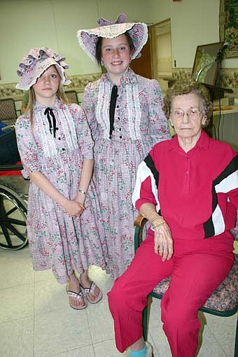 Mackenzie Stevens, 10, of Rochester, left, and Amy Hintz, a Stewartville sixth-grader, wore dresses made  50 years ago by Care Center resident Lornice Amos, seated. 