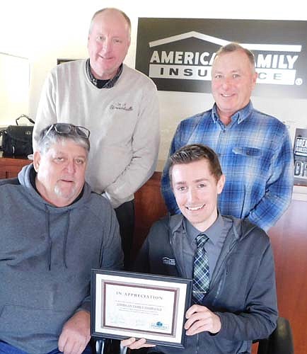 Tyler Welhaven, branch manager of Stewartville's American Family Insurance office, seated at right, accepts the EDA's Business Appreciation Award from, clockwise from lower left, Jim Kuisle, president of the EDA; Bill Schimmel Jr., city administrator; and Mayor Jimmie-John King, a member of the EDA.
