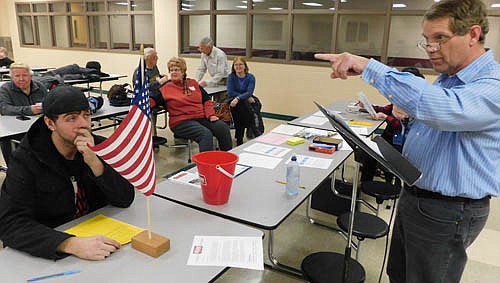 Kent Larson, precinct co-chair, right, points to a resident in the audience at the Republican Precinct Caucus at Stewartville High School on Tuesday evening, Feb. 25. About 20 local Republicans attended the event.