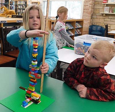 After her younger brother Brody, right, built a tower during the Stewartville Public Library's LEGO program on Tuesday afternoon, March 10, Addy Blake, 9, of Pleasant Grove, measures just how tall Brody's tower is.  On each consecutive Tuesday of each month, the library highights a particular theme, either a LEGO program, a craft project, a STEM opportunity or a game night.