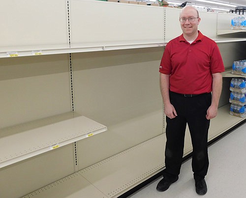 Robert Hruska, grocery manager at Fareway, Stewartville's grocery store, stands near the shelves emptied of toilet paper and paper towels last week. Shoppers concerned about the spread of the COVID-19 virus quickly bought all the store's toilet paper, paper towels, hand sanitizer and more.