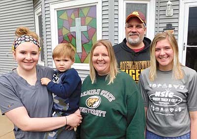 On Palm Sunday, a Stewartville family worked together to paint a cross on the east window of their house at 307 First Street East. Workers included Tom Passe, second from right, and Molly Christenson, third from right, their daughters, Abby Christenson, far left, and Libby Christenson, far right, along with Abby's son Liam, 3, held by his mother. "I got the idea from some co-workers," Molly said. "We decided on the cross because it's Easter."