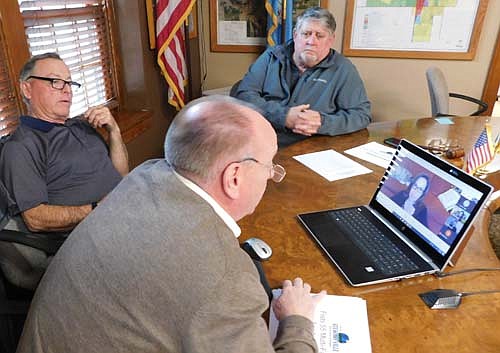 Mindful of the coronavirus (COVID-19) pandemic, the city of Stewartville's Economic Development Authority held a virtual meeting via Google hangouts on Tuesday evening, April 21. Above, from foreground to background, Bill Schimmel Jr., city administrator; Mayor Jimmie-John King, a member of the EDA; and Jim Kuisle, EDA president, together at Stewartville City Hall, listen to Heather Holmes of Community &&#8200;Economic Development Associates (CEDA) of Chatfield, who speaks to the EDA about Flats 55, a 55-unit apartment complex to be built near Bear Cave Intermediate School.