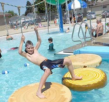 Liam Brost, 9, a homeschooled student from Rochester, is one of hundreds of kids who used hanging ropes to cross the imitation logs at the Stewartville pool on Wednesday afternoon, June 17. The Stewartville City Council, at its Tuesday, June 9 meeting, agreed to open the pool at 50 percent capacity with the stipulation that swimmers follow safety guidelines to prevent the spread of the coronavirus (COVID-19). Liam enjoyed his time at the pool. "It's nice," he said. "The slides look a little freaky, since I'm afraid of heights...There is a nice play area for the little ones."