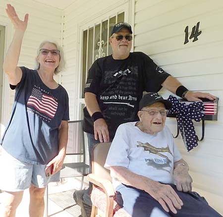 Joyce Johnson, seated at right, watches his many friends drive past his Racine home to wish him a happy 99th birthday on Sunday afternoon, July 19. Standing behind Johnson are his daughter, Vicki Hoover, left, and his son, Terry Johnson.