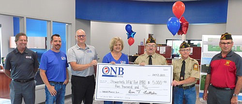 ONB Bank of Stewartville celebrated its grand opening last week by writing a $5,000 check to help pay for the new VFW Veterans Memorial Park to be built near the city's south entrance. From left, ONB representatives Ed Hruska, business development officer; Josh Buckmeier, vice president and commercial lender; Brad Becker, president and CEO; and Ann Lutteke, vice president and branch manager, present the check to Roger Peterson, commander of the Stewartville American&#8200;Legion Post 164 and an active member of the VFW, third from right; Roger Barsness, quartermaster (treasurer) of the VFW, second from right; and Ed&#8200;Krusemark, a member of the VFW and the Veterans Memorial Park Committee.