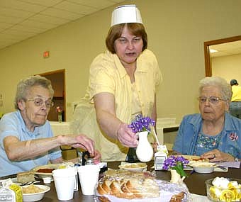 Shirley Hinze, the new coordinator of Senior Services, Inc., Stewartville, center above, assists June Stelter, left, and Betty Mace during lunch at the Stewartville Civic Center last week. 