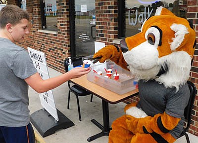 Brady Ploenzke, otherwise known as the Stewartville Tiger Mascot, hands a free sample of a caramel applie pie Blizzard to Carson Goodman, who will be a sixth grader at Stewartville Middle School, at Stewartville's Dairy Queen last week.