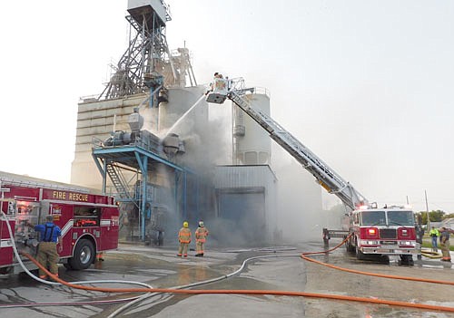 Stewartville firefighters used the department's new ladder truck to attack a fire at All American Co-op on Thursday morning, Sept. 17. A soybean roaster at the Co-op caught fire, sending a column of smoke into the air.
