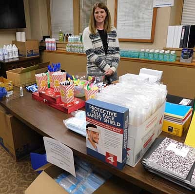 Karla Strain, city finance director, poses near some of the items available at the small store at the lower level of Stewartville City Hall. City officials bought face shields, masks and other anti-COVID-19 items to give away at City Hall in mid-September.