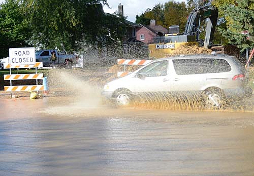 Workers accidentally broke a water main along Lakeshore Drive near North Main Street last week, sending water streaming down and across Main Street. Above, a vehicle splashes through the gathering water.