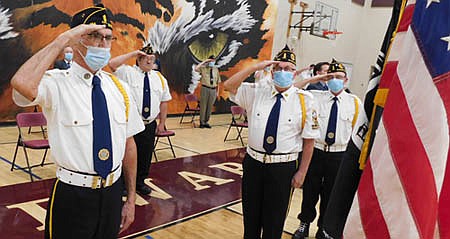 Members of the Stewartville American Legion Post 164 saluted the flag at a virtual Veterans Day ceremony at the Stewartville High School gym on Tuesday evening, Nov. 10. Legion members in the foreground, from left, include Ron Moore, Commander Roger Peterson, Dave Nystuen and Randy Welter.