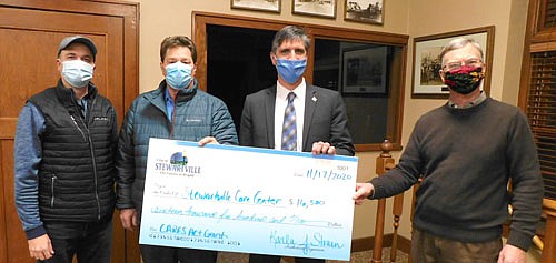 Gene Gustason, administrator of the Stewartville Care Center, second from left; along with Jarett Jones, second from right, and Pastor Byron Meline, far right, members of the Care Center Board, accept a $16,500 check in CARES Act funding from the Economic Development Authority (EDA), represented by Adam Wright, far left. Gustason said the funds will help the Care Center pay for increased COVID-19 testing.