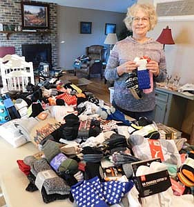 Carol Youdas, a member of the Stewartville Kiwanis Club and chair of the club's annual "Sock It To 'Em" Sock Drive, displays many of the more than 450 pairs of socks local and area residents brought to Bremer Bank from Monday, Nov. 2 through Monday, Nov. 30. The socks will be distributed to Stewartville schools and The Landing MN in Rochester, which serves homeless people, Youdas said