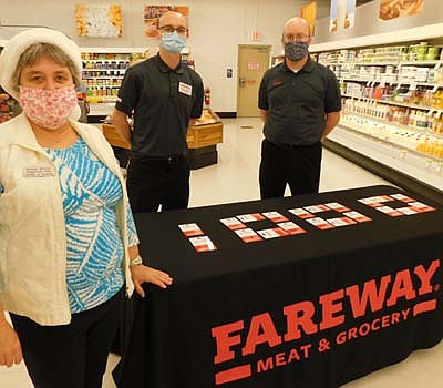 Fareway, Stewartville's grocery store, has distributed 20 Fareway gift cards, worth $50 each, or a total of $1,000, to the Stewartville Area Chamber of Commerce, which will pass along the cards to Chamber-member businesses struggling as a result of the coronavirus (COVID-19) pandemic. Myrna Welter,  Chamber membership coordinator, in the foreground at left, accepts the cards from Stephen Heffernen, assistant manager of Fareway, in the background at left; and Robert Hruska, Fareway's grocery manager.