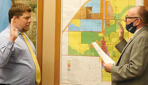 Jeremiah Oeltjen, left, re-elected to a second term as a councilperson on the Stewartville City Council, takes the oath of office for another four- term from Bill Schimmel Jr., city administrator, at City Hall on Tuesday evening, Jan. 12.