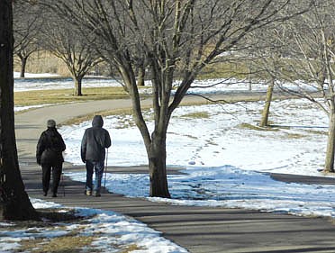 Enjoying mild temperatures in the upper 30s, a couple walk together on a path near the Florence Park Pond on Tuesday afternoon, Jan. 12. However, forecasters predicted colder temperatures with a chance for about four to six inches of snow later in the week.