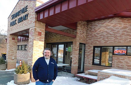 Nate Deprey, director of the Stewartville Public Library, stands near the building's entrance where a new, lighted sign in the front window declares that the library is open. "People were having a hard time telling whether we were open or not," Deprey said. "This has added to our street presence. It says, 'We are open. Come on in." The city paid about $140 on Amazon for the LED, low-energy sign, Deprey said.