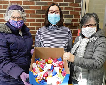 Carol Youdas, left, and Glynis Sturm, right, members of the Stewartville Kiwanis Club, delivered Hershey's Kisses to Stewartville's teachers, paraprofessionals, custodians and support staff at all the district's schools last week. Above, Youdas and Sturm share the candy with Ellen Rollie, school district nurse, also a member of the Kiwanis Club, at the Central Education Center on Tuesday morning, Feb. 16. The Kisses came with a message for all district staff: "We are ready to KISS!' COVID-19 goodbye. We PROMISE to continue to support Stewartville Schools. You are much appreciated. With hope from the Stewartville Kiwanis Club."