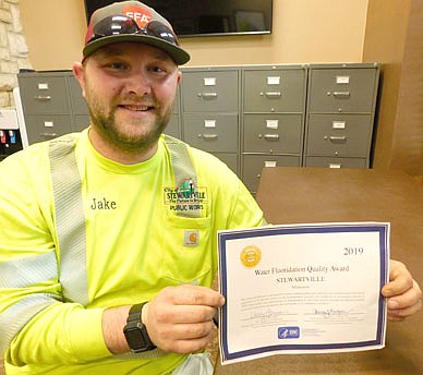 Jake Burzinski, lead water operator for the city of Stewartville, displays the Water Fluoridation Quality Award the city received from the Centers for Disease Control and Prevention, a division of the U.S. Department of Health and Human Services.