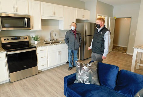 Nate Carty of Realty Growth of Rochester (RGI), right, leads Mayor Jimmie-John King on a tour of a Flats 55 apartment's kitchen on Friday, March 5. Chamber of Commerce and city officials took the tours to celebrate the opening of the 55-unit, four-story, 73,000 square-foot building.
