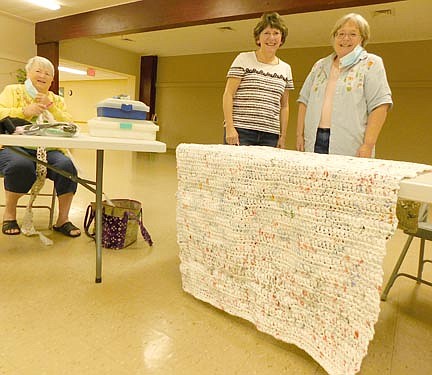 Carol Cole visited Zion Lutheran Church last week to crochet plastic bags into mats for the homeless. Every evening at home, she crochets for about three hours as she watches television. Above, from left, crocheters Cole, Kathy Ottjes and Jo Olson pose near a completed mat.